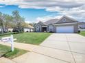 Single-story home with an expansive driveway, green lawn, and welcoming exterior at 126 Dairy Farm Rd, Mooresville, NC 28115