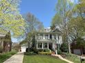 Charming two-story home featuring a welcoming front porch, lush landscaping, and a well-manicured lawn at 307 N Downing St, Davidson, NC 28036