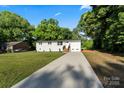 Spacious single-story home with a long driveway, fresh paint, and lush green lawn at 3423 Archer Ave, Charlotte, NC 28217