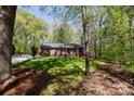 One-story brick home nestled in a lush, wooded setting with a well-maintained lawn and inviting front porch at 4289 Falcon Hall Way, Rock Hill, SC 29730