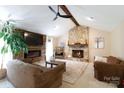 Inviting living room with stone fireplace, vaulted ceilings, wood beam, and cozy seating arrangement at 4289 Falcon Hall Way, Rock Hill, SC 29730
