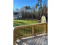 Spacious backyard with lush lawn, mature trees, storage shed, and view of the home from a wood deck at 4476 River Rd, Stanfield, NC 28163