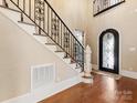 Beautiful foyer with high ceilings, hardwood floors, and custom iron staircase at 703 Sainte Rose Ln, Charlotte, NC 28226