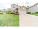 Charming two-story home with a well-manicured lawn, two car garage and a basketball hoop at 807 Oak Manor Se Dr, Concord, NC 28025