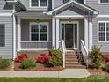 Inviting front porch with white railings and brick steps, surrounded by lush landscaping at 811 Penny Royal Ave, Fort Mill, SC 29715