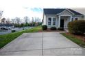 Paved driveway to home with manicured lawn and green bushes at 101 N Ferncliff Dr, Mount Holly, NC 28120