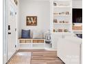 Inviting entryway with a bench, storage baskets, shelving, and hardwood floors offering a stylish and functional space at 103 Claremont Way, Mooresville, NC 28117