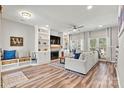 Bright living room with a fireplace, built-in shelving and bench, and wood flooring at 103 Claremont Way, Mooresville, NC 28117