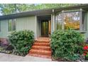 Front entry with brick steps, lush greenery, and unique window design at 109 Canterbury Ln, Matthews, NC 28104