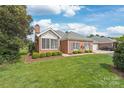 Beautiful brick home with well-maintained lawn and lush landscaping, showcasing classic charm at 11346 Olde Turnbury Ct, Charlotte, NC 28277