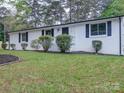 Charming white brick home with black shutters and well-maintained front yard landscaping at 1159 Ragan Dr, Gastonia, NC 28054