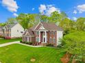Spacious brick home with well-maintained lawn and landscaping, showcasing curb appeal at 130 Weeping Spring Dr, Mooresville, NC 28115