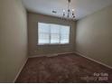 Bright bedroom with large window offering natural light and a cozy chandelier at 13409 Glasgow Green Ln, Charlotte, NC 28213