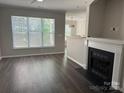 Bright living room showcasing a fireplace, large window and modern flooring at 14208 Castle Abbey Ln, Charlotte, NC 28277
