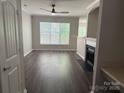 Bright living room featuring hardwood floors, fireplace, and large windows for natural light at 14208 Castle Abbey Ln, Charlotte, NC 28277