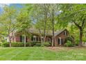 Attractive brick home with lush landscaping, mature trees, and a well-maintained lawn at 2234 Hamilton Mill Rd, Charlotte, NC 28270
