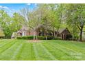 Lovely brick home with mature trees, a lush green lawn, and charming curb appeal at 2234 Hamilton Mill Rd, Charlotte, NC 28270