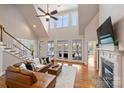 Spacious living room with vaulted ceilings, large windows, fireplace, and access to a deck with lake views at 272 Harbor Ridge Dr, Statesville, NC 28677