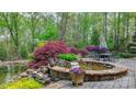 Beautiful backyard oasis featuring a tranquil pond, waterfall, and outdoor seating area at 305 Caledonia Way, Waxhaw, NC 28173