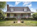 Charming brick home featuring a cozy front porch, dormer windows and well-maintained landscaping at 44392 Dennis Rd, Albemarle, NC 28001