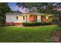 Charming brick home at twilight, featuring a well-manicured lawn and lush landscaping at 576 Scaleybark Rd, Charlotte, NC 28209