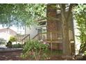 Backyard view showcasing a raised wooden deck, brick chimney, and lush landscaping, ideal for relaxation at 5769 Birch St, Conover, NC 28613