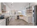 Bright, open kitchen with white cabinetry, marble backsplash, and a copper sink at 618 Circle Trace Rd, Monroe, NC 28110