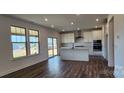 Bright, open kitchen with stainless appliances, island, and sliding glass doors at 642 Amberjack Pl # 75, York, SC 29745