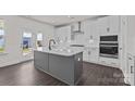 Modern kitchen with white cabinets, a gray island, stainless steel appliances, and hardwood floors at 642 Amberjack Ln, York, SC 29745