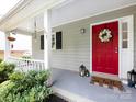 Welcoming front porch with a bright red door and lovely decorative touches at 7820 Elm Tree Ln, Charlotte, NC 28227