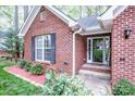 Close-up of front entrance featuring brick facade, welcome mat, and well-maintained landscaping at 1050 Emerson Dr, Mooresville, NC 28115