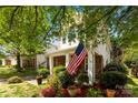 Inviting home exterior with a brick porch, American flag, and colorful flower beds at 12319 Cumberland Cove Dr, Charlotte, NC 28273