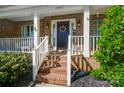 Close-up of the front door with a wreath, brick steps, and white railings at 15407 Saxon Trace Ct, Huntersville, NC 28078
