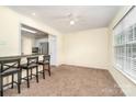 Bright dining area featuring plush carpet, a ceiling fan, and a pass-through to the kitchen at 225 Carrie Ct, Concord, NC 28027