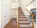 Inviting foyer showcasing hardwood floors, a carpeted staircase, and a view into adjacent rooms at 225 Carrie Ct, Concord, NC 28027