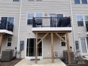A view of the back of the home, featuring a small deck overlooking a concrete backyard at 2315 Doby Creek Ln # 77, Charlotte, NC 28262