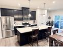 Modern kitchen featuring dark cabinetry, stainless steel appliances, and a large center island with quartz countertops at 2315 Doby Creek Ln # 77, Charlotte, NC 28262
