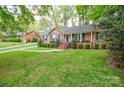 Well-maintained front yard with lush green lawn leading to the brick home with black shutters at 2429 Sugar Mill Rd, Charlotte, NC 28210