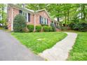 Low angle view showing the green lawn, sidewalk, and brick facade of the house at 2429 Sugar Mill Rd, Charlotte, NC 28210