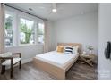 Cozy bedroom featuring a minimalist bed frame, neutral-toned decor, and ample natural light at 2890 Westshore Pl, Denver, NC 28037