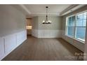 Open dining room with wainscoting, hardwood floors, and an elegant chandelier at 3214 Mcharney Dr # 34, Harrisburg, NC 28075