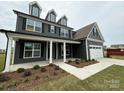 Beautiful two-story home featuring a welcoming porch, dark siding, and a well-maintained front yard at 3214 Mcharney Dr # 34, Harrisburg, NC 28075