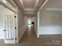 Bright hallway with wainscoting and hardwood floors leading to a living space at 3214 Mcharney Dr # 34, Harrisburg, NC 28075