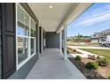 Covered porch features classic columns, neutral gray siding, and manicured landscaping at 3214 Mcharney Dr # 34, Harrisburg, NC 28075