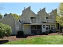 Rear view of a townhome with a screened porch and a balcony overlooking a green lawn at 331 Eastwood Dr, Salisbury, NC 28146