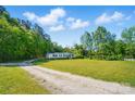 Spacious front yard view of home with mature trees surrounding it at 3678 Old Camden Hwy, Heath Springs, SC 29058