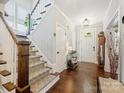 Bright foyer with hardwood floors, a staircase with patterned carpet, and decorative lighting at 423 Sensibility Cir, Fort Mill, SC 29708