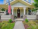 Inviting front porch with decorative columns, stone accents, a welcome mat, and an American flag display at 423 Sensibility Cir, Fort Mill, SC 29708