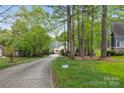 A long driveway to a beautiful home surrounded by lush greenery and mature trees at 4525 Island Waters Dr, Denver, NC 28037