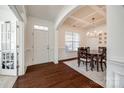 Elegant foyer and dining room boasts wood floors, coffered ceilings, and neutral walls at 5716 Langwell Ln, Charlotte, NC 28278
